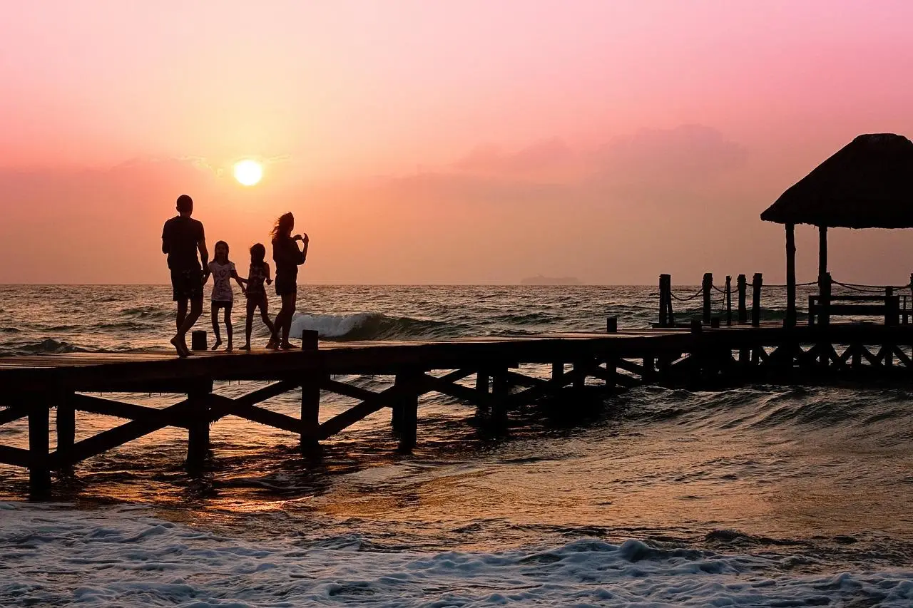 Family by the pier. Sunset. Life is good once they got affordable Life insurance.