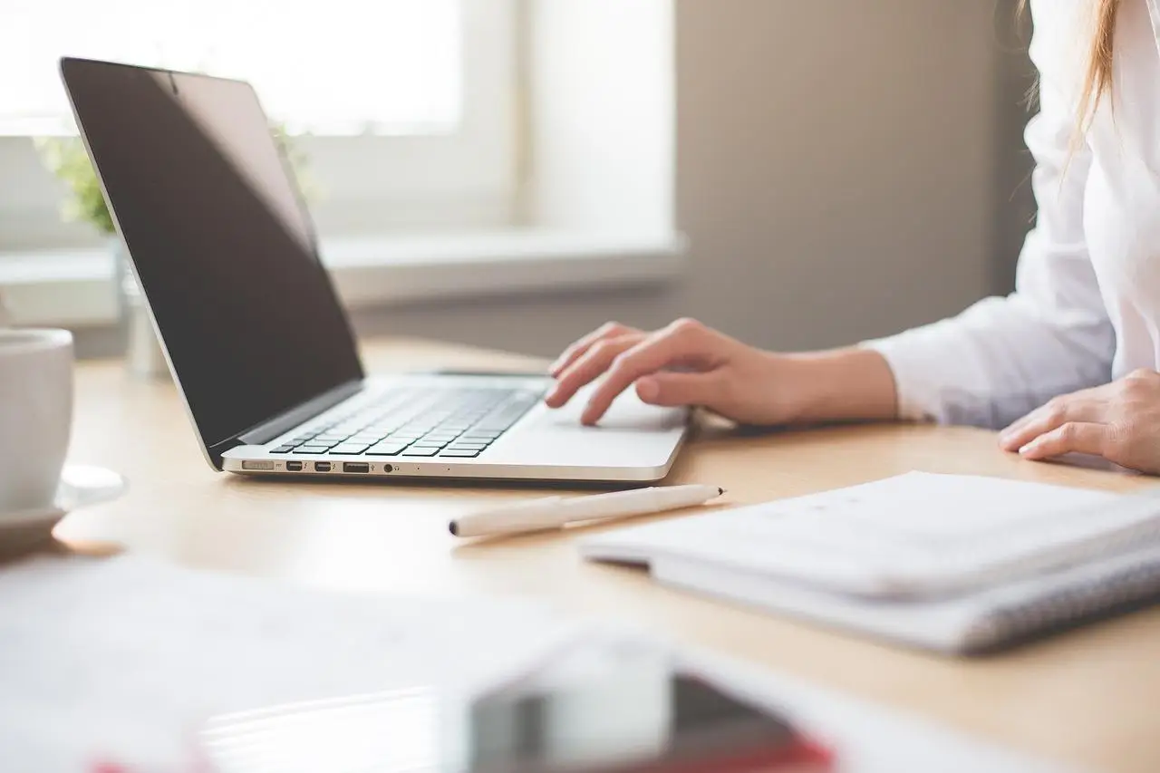 Hand scrolling on laptop for insurance policies